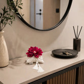 Decoración textil SimLi con flor roja sobre mueble de recibidor