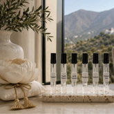 Colección SimLi Fragancias para Textiles 10 ml con seis aromas artesanales: Toskana, Sueño Blanco, Jardín Secreto, Marrakech, Santorini y Bosque Vivo, presentada en un elegante interior contemporáneo con vistas a las montañas de Málaga.