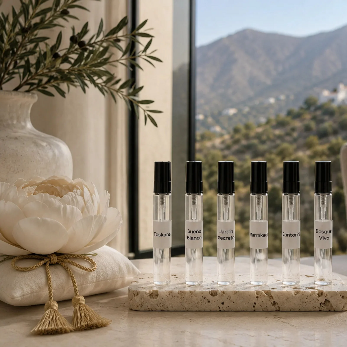 Colección SimLi Fragancias para Textiles 10 ml con seis aromas artesanales: Toskana, Sueño Blanco, Jardín Secreto, Marrakech, Santorini y Bosque Vivo, presentada en un elegante interior contemporáneo con vistas a las montañas de Málaga.