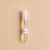 Frasco de 5 ml de la fragancia textil Bosque Vivo de SimLi con líquido visible sobre fondo beige