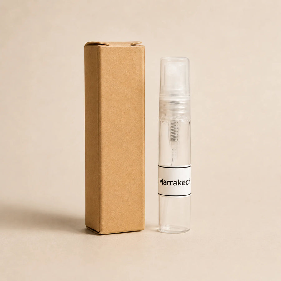 Fragancia textil Marrakech de 5 ml de SimLi junto a su caja kraft sobre fondo beige.