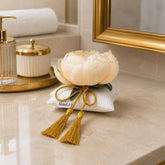 Decoración textil Alba Peonía sobre encimera en un ambiente de baño con detalles decorativos en tonos suaves.