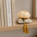 Decoración textil Alba Peonía sobre estantería de madera junto a libros de hogar y decoración.