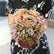 Arreglo floral artificial vintage sostenido en las manos para mostrar su tamaño y volumen