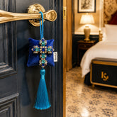 Cruz de Amalfi, colgante decorativo artesanal de SimLi Atelier colocado en la manilla de una puerta de un hotel boutique.