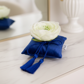 Elemento de decoración aromática de terciopelo azul para perfumar el hogar, con rosa blanca y borlas.