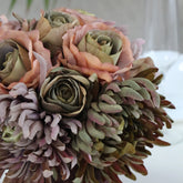 Detalle de rosas artificiales y crisantemos en una composición floral de estilo vintage