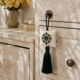 Esmeralda de Marbella colgado en un pomo decorativo de un mueble.