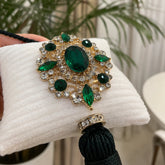 Detalle del broche verde y los acabados decorativos de Esmeralda de Marbella.