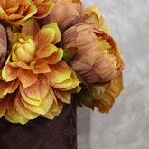 Detalle de peonías y dalias artificiales en tonos amarillos, naranjas y tierra