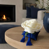 Decoración textil Perla de Cádiz sobre una mesa de madera en un ambiente mediterráneo.