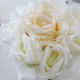 Primer plano de varias rosas blancas artificiales con pétalos en tonos blanco y marfil