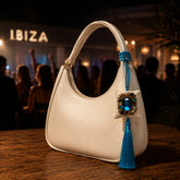 Zafiro de Ibiza de SimLi colgado en un bolso blanco en un ambiente nocturno inspirado en Ibiza