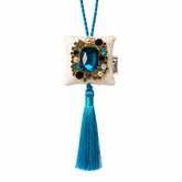 Colgante decorativo textil Zafiro de Ibiza de SimLi Atelier con cristal azul sobre fondo blanco